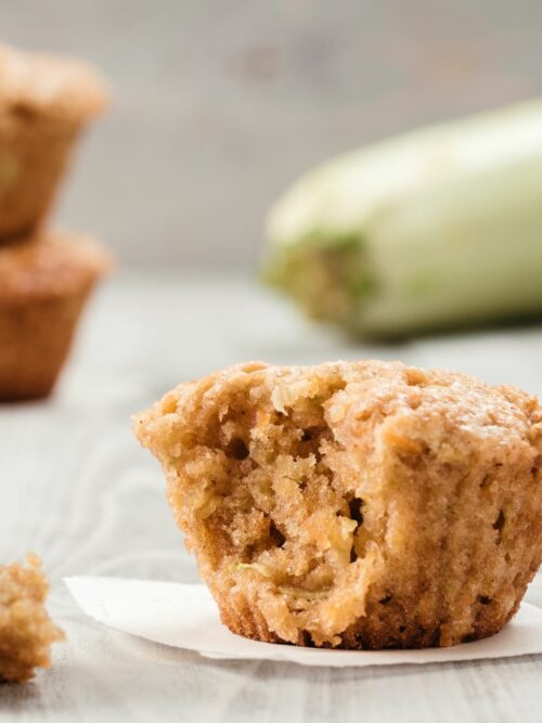A cukkinis-sárgarépás muffinokat cukkinivel a háttérben tálalhatod