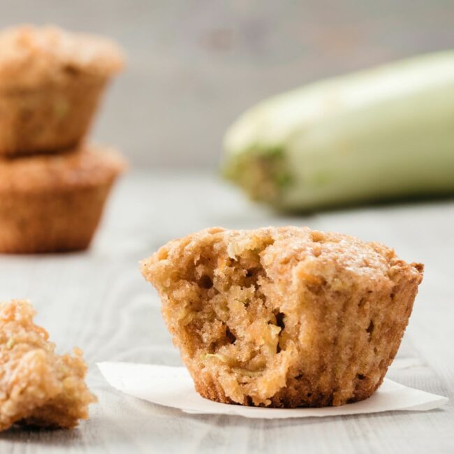 A cukkinis-sárgarépás muffinokat cukkinivel a háttérben tálalhatod