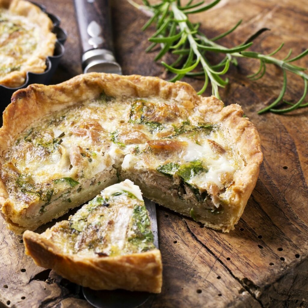 Quiche mit Thunfisch-Spinat-Füllung wird angeschnitten serviert.
