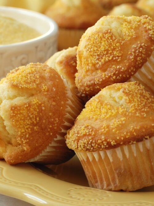 A kukoricakenyér muffinok sárga tányérra halmozva láthatók.