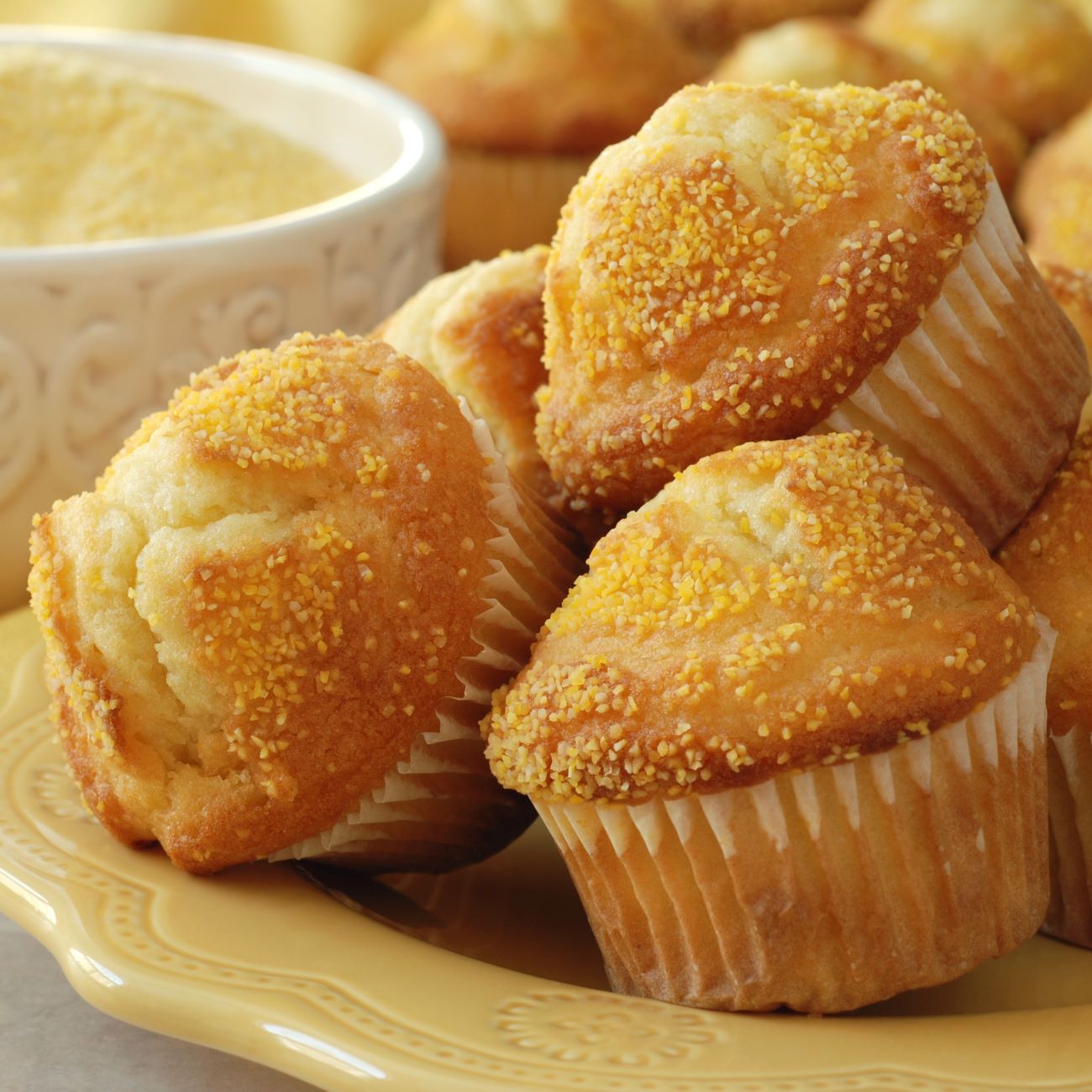 A kukoricakenyér muffinok sárga tányérra halmozva láthatók.