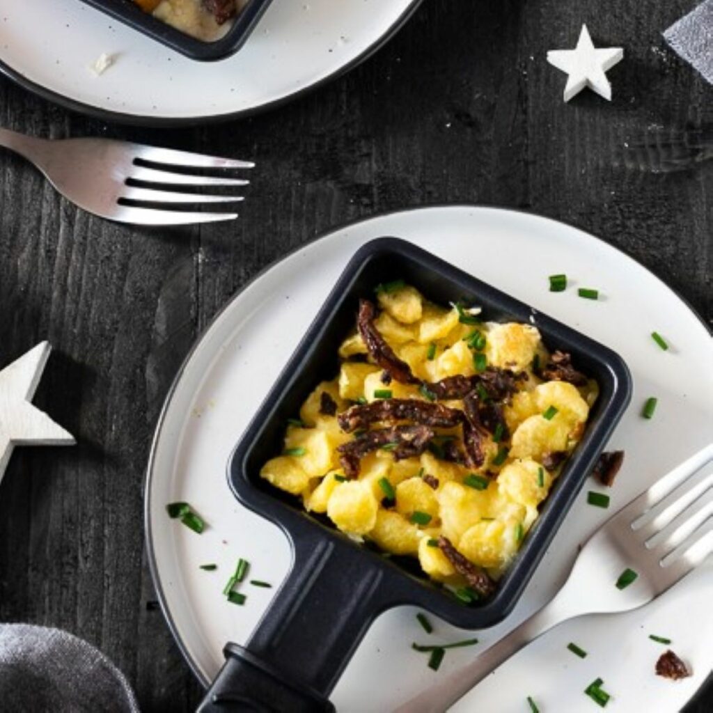 Käsespätzle-Raclette-Pfännchen von oben gezeigt