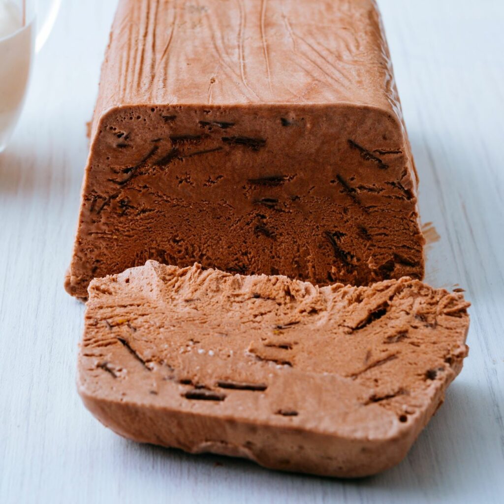 A csokoládé parfé fehér fatáblán szeletelve látható.