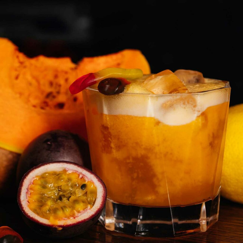 Halloween Punsch wird in einem Glas mit Gummi-Würmern serviert.