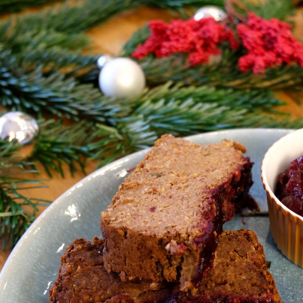Nussbraten wird aufgeschnitten ganz nah mit Cranberry-Sauce gezeigt.