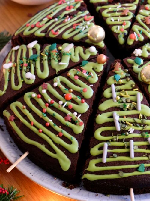 Gewürzkuchen wird mit weihnachtlicher Verzierung in Stücke geschnitten gezeigt.