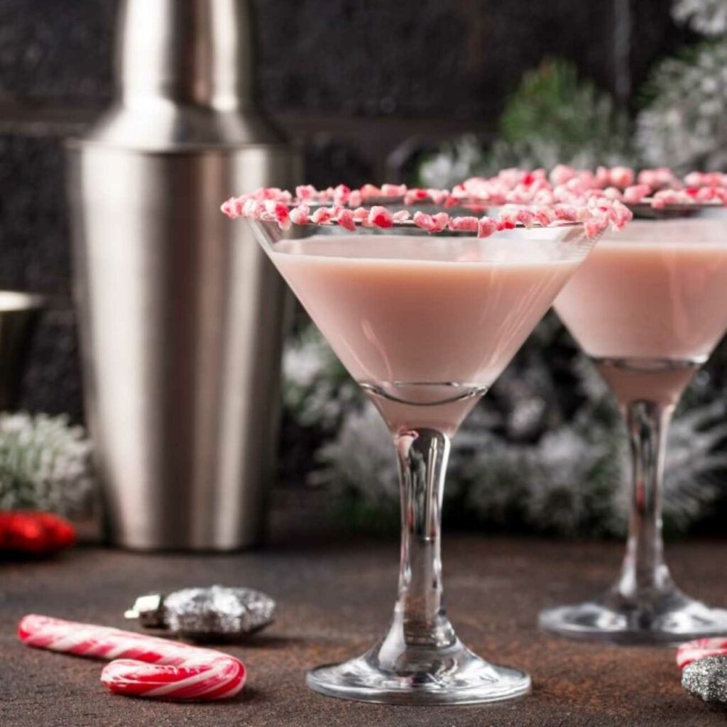 Candy Cane Martini wird mit Zuckerstangen serviert.