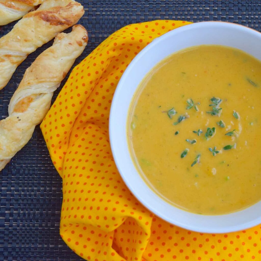 A burgonya curry levest gyógynövényekkel, kenyérpálcikákkal tálalják.